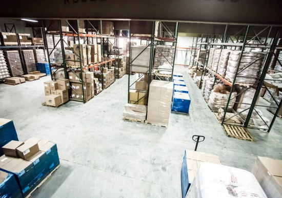 Viacore warehouse with cardboard boxes of product on industrial shelving as well as pallets of boxes